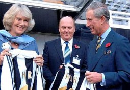 Freddy Shepherd, entre los Príncipes de Gales, que posan exhibiendo dos camisetas del Newcastle.  Foto: Ap